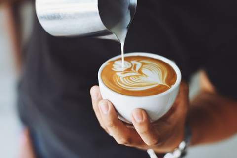 A latte with foam art in a white cup