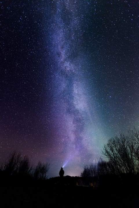 A starry night sky over a dark horizon